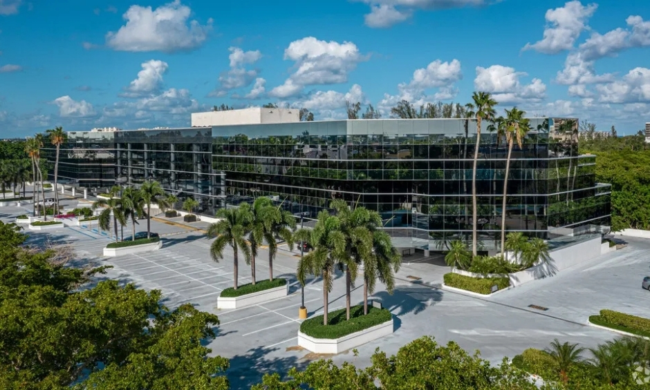Office building with black windows, blue skies, palm trees
