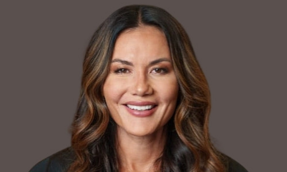 Women with long dark wavy hair, black top, dark background