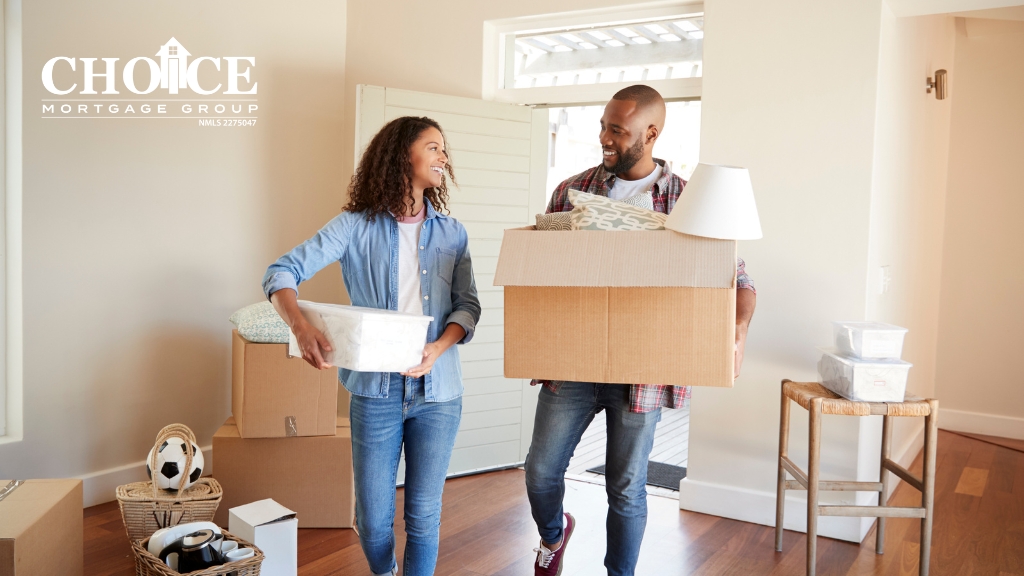 African American couple carrying moving boxes into new home